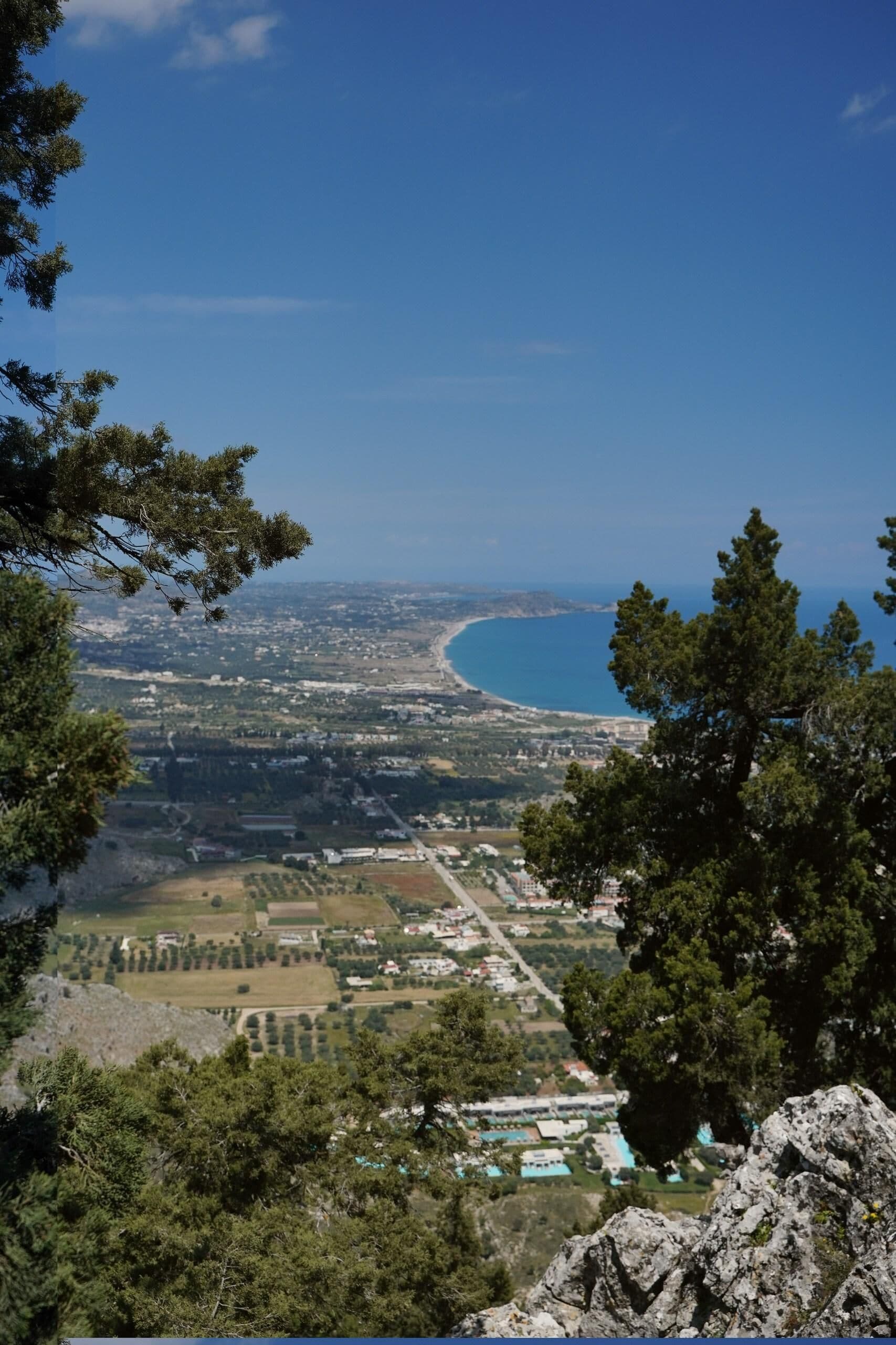 A coastal landscape with a clear view of the sea and a town below.
