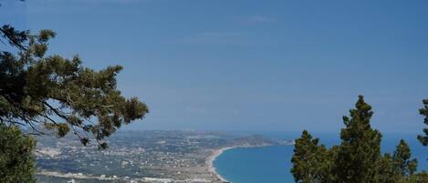 A coastal landscape with a clear view of the sea and a town below.