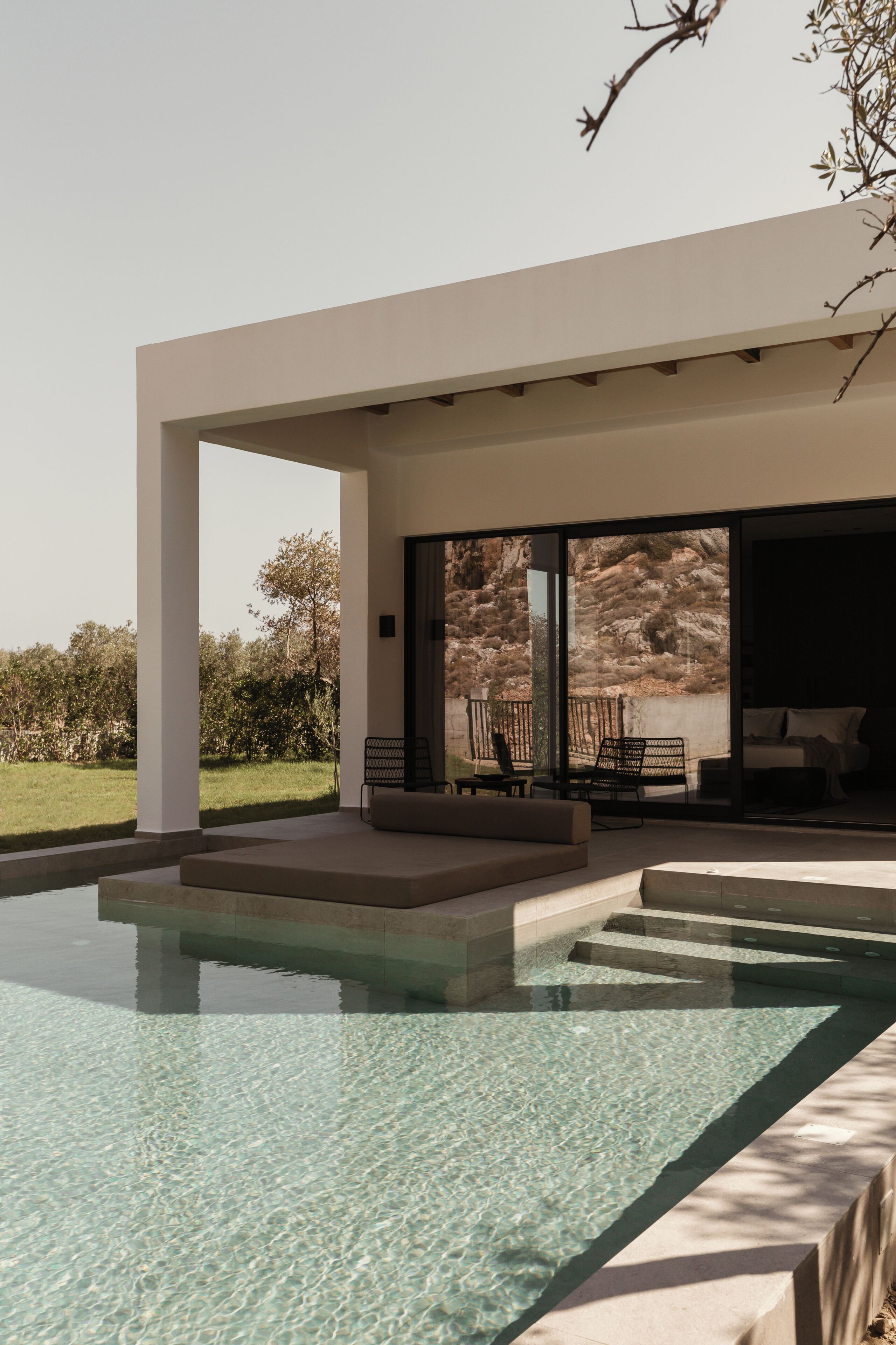 Una casa moderna con piscina, mobiliario de exterior y vistas al paisaje.