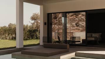 Una casa moderna con piscina, mobiliario de exterior y vistas al paisaje.