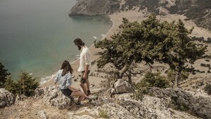 A coastal landscape with rocky terrain and a beach.
