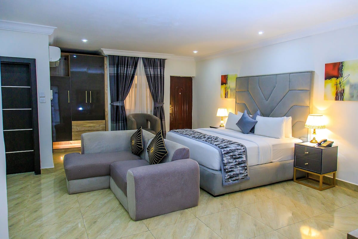 A bedroom with a bed, bedside tables, a chair, and a wardrobe.
