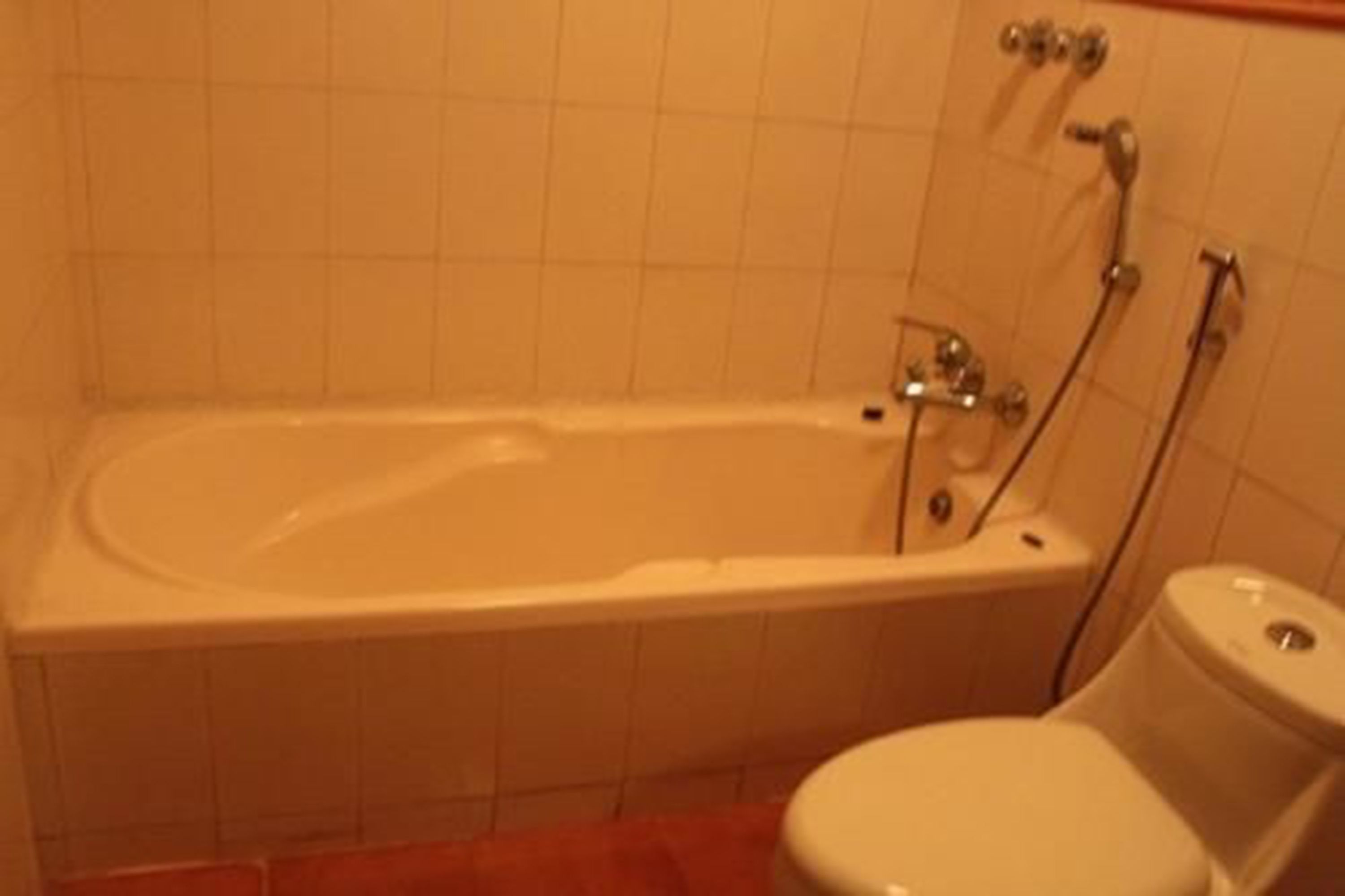 A standard bathroom with a bathtub, toilet, and shower.