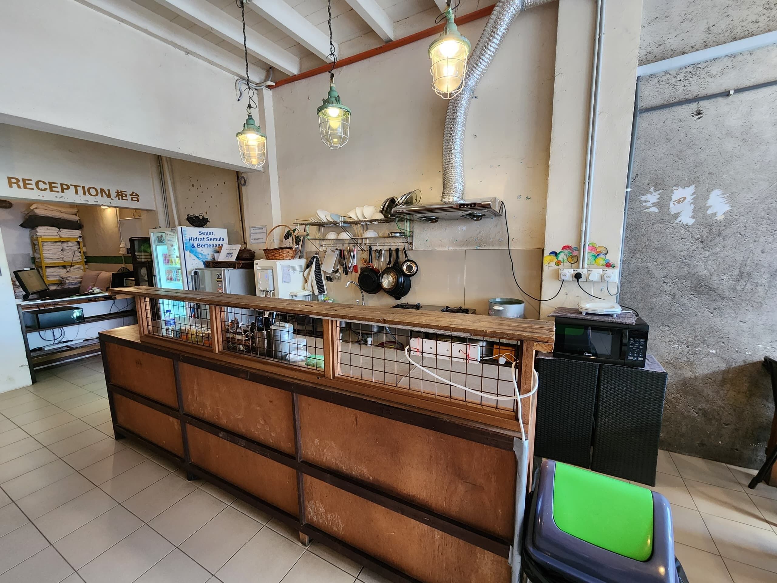 A reception area with a wooden counter, metal shelving, and hanging lights.