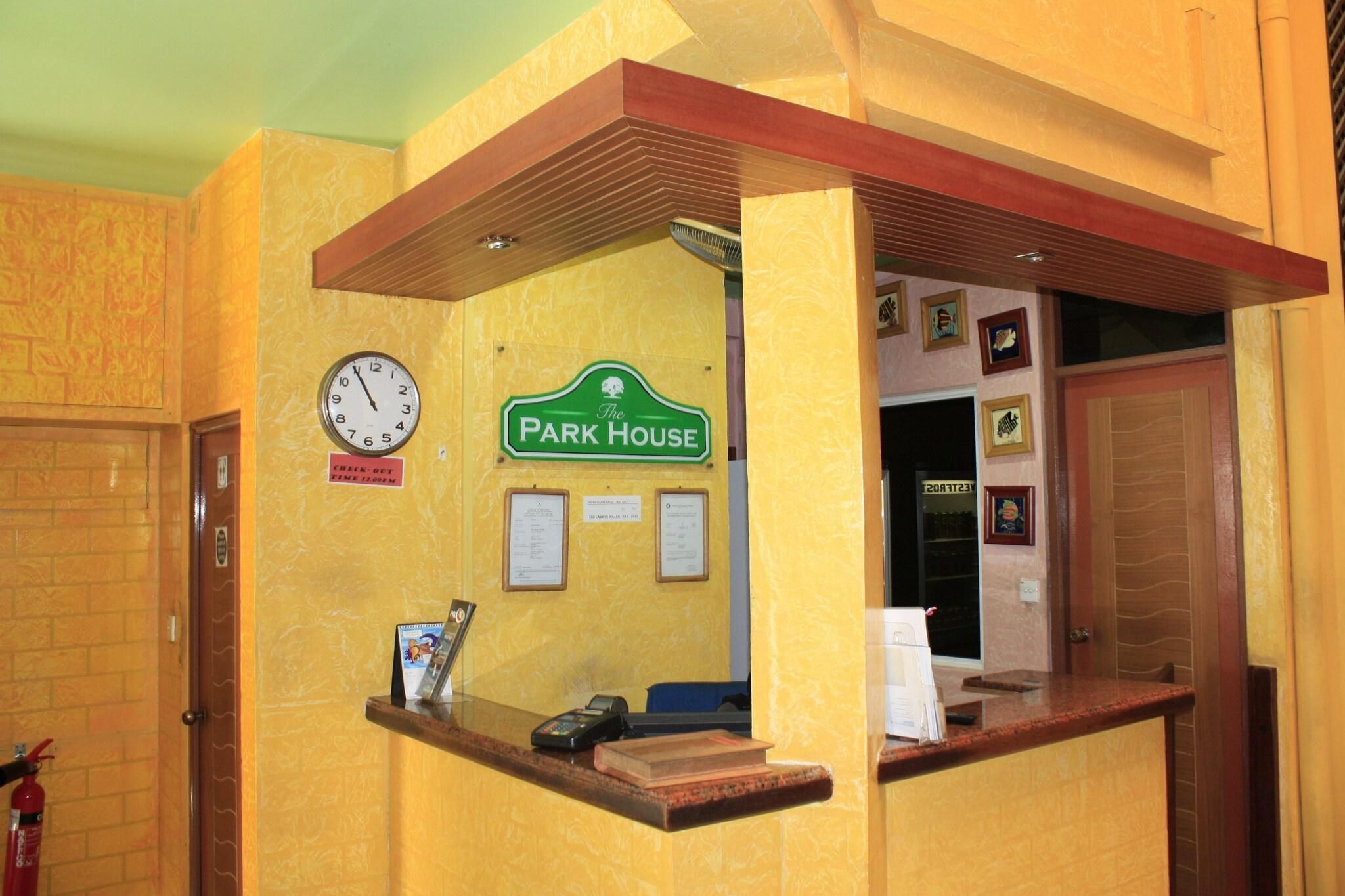 A reception area with a clock, a sign reading 'The Park House,' and a fire extinguisher.