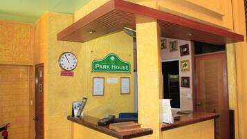 A reception area with a clock, a sign reading 'The Park House,' and a fire extinguisher.
