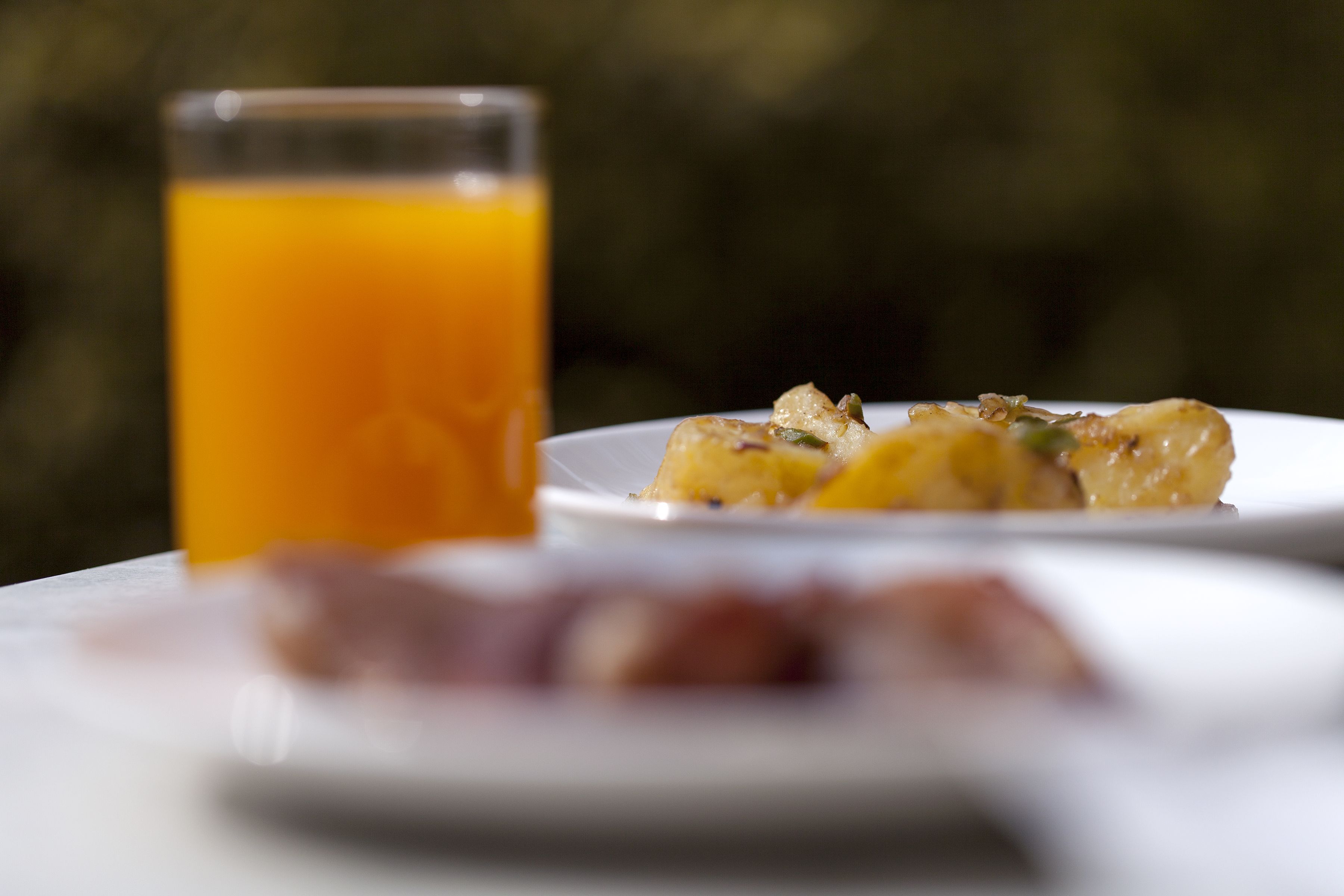 Un desayuno con un vaso de jugo de naranja y un plato de comida.