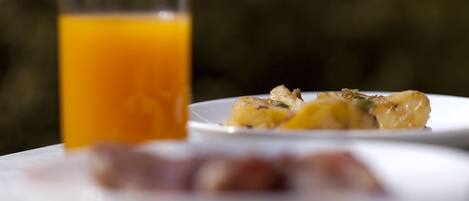 Un desayuno con un vaso de jugo de naranja y un plato de comida.