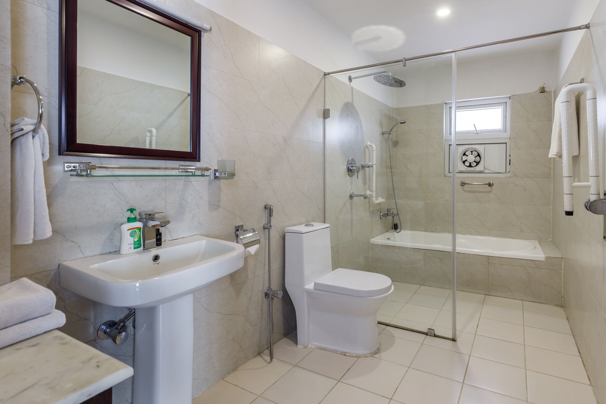Une salle de bain moderne avec une douche à parois de verre, un lavabo blanc et des toilettes.