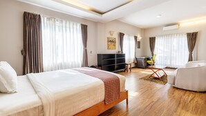 A modern hotel room with a large bed, a desk, a sofa, and a TV. - Shaligram Hotel (Lalitpur)
