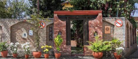 A brick entrance with a sign reading "SPA" and a no-smoking sign.