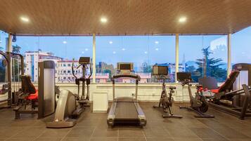 A gym with cardio machines, a treadmill, and a rowing machine.