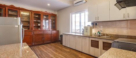 Una cocina con armarios de madera, encimeras de granito y horno empotrado.