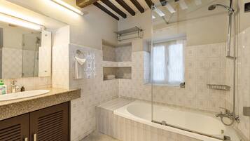 A modern bathroom with a freestanding bathtub, a glass-enclosed shower, and a vanity with a sink and mirror.