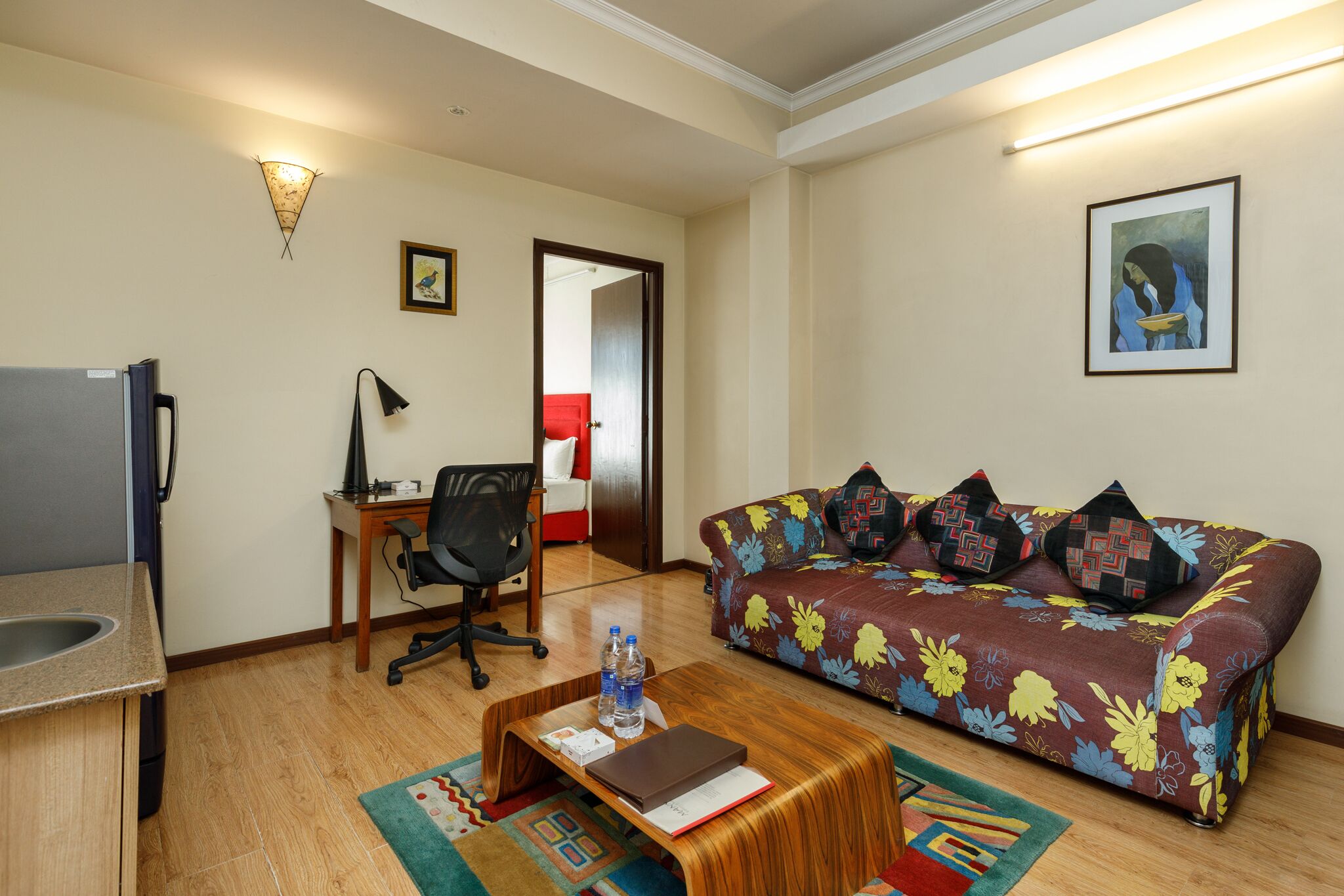 Una sala de estar con sofá, mesa de centro, escritorio y una silla.