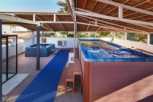 Una piscina al aire libre, sillones reclinables de piscina