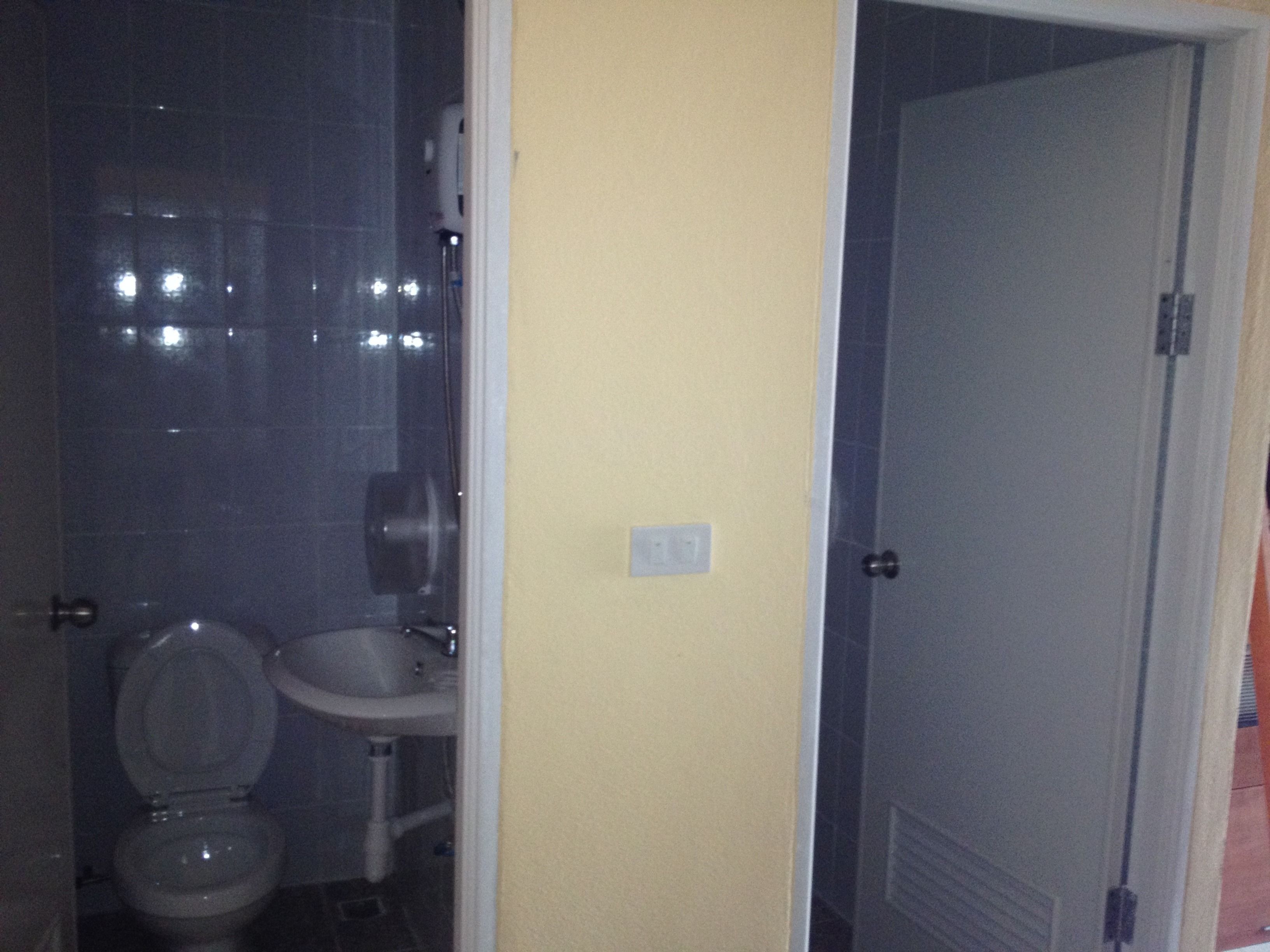 A bathroom with a toilet, sink, and shower area.