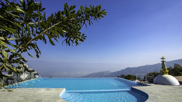 A swimming pool with a view of mountains and a clear sky.