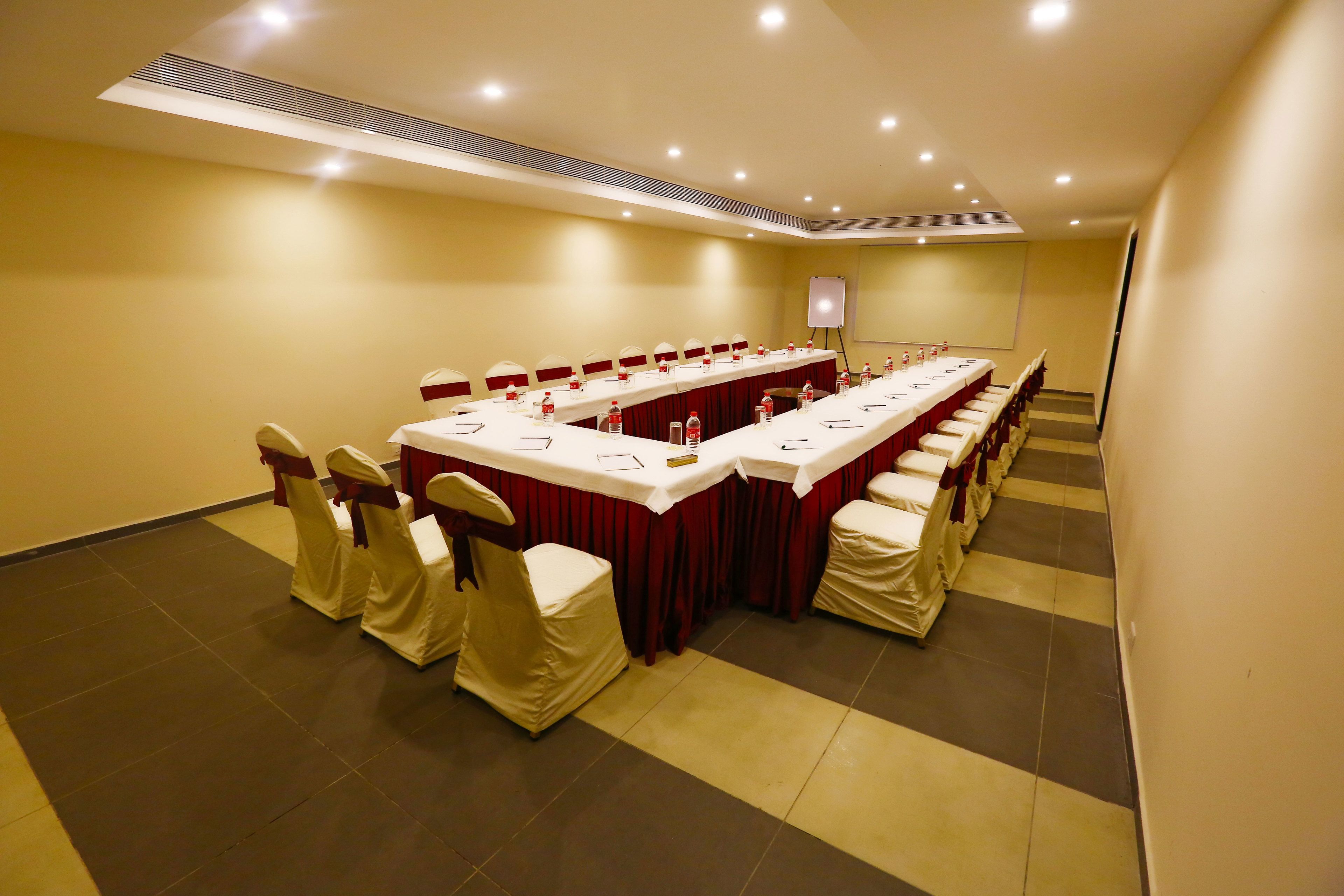 A conference room with a long table, chairs, and a whiteboard.