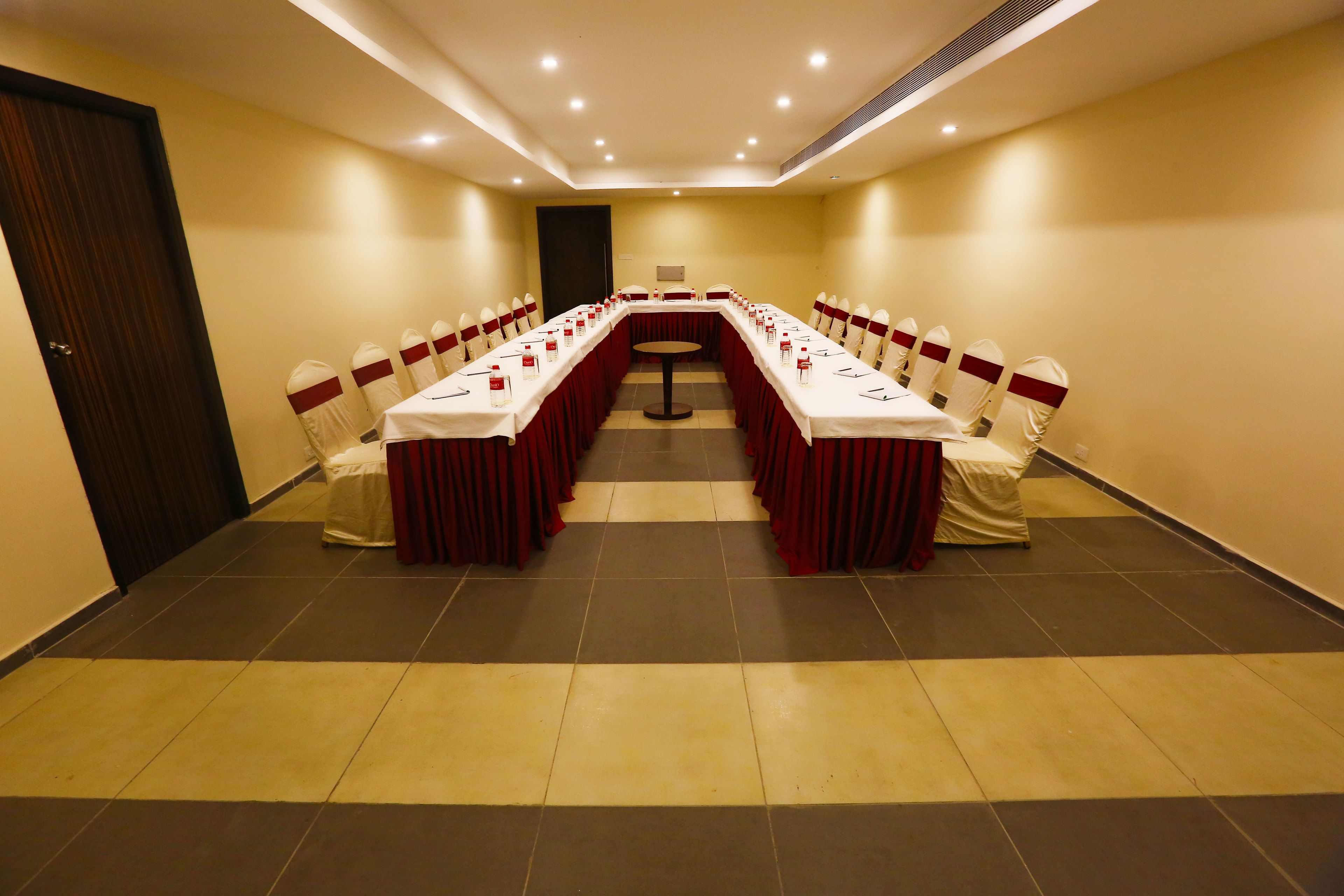 A conference room with a long table, chairs, and a podium.