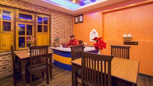 Un restaurante con pared de ladrillo, mobiliario de madera y un letrero que indica 'No Fumar'.