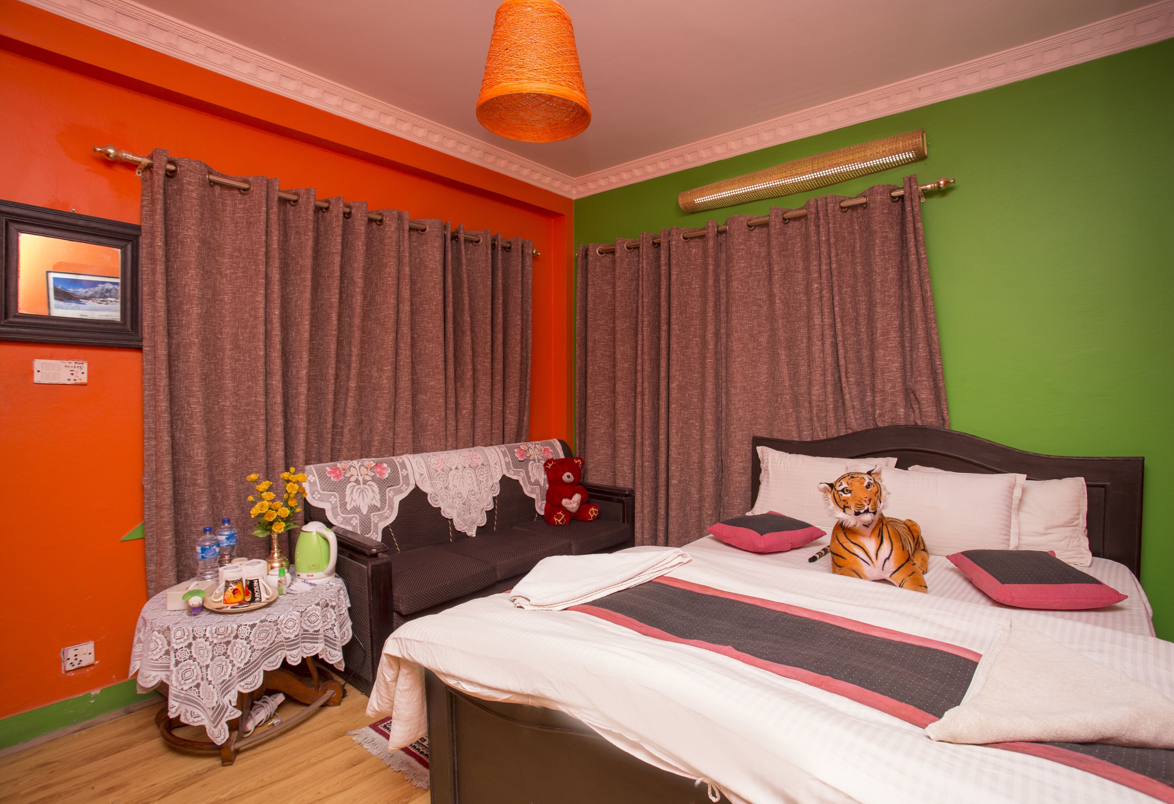 A bedroom with a bed, a nightstand, a lamp, and a teddy bear.