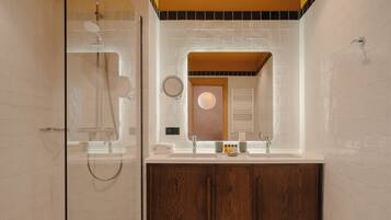 A modern bathroom with a glass shower enclosure, a vanity with a mirror, and wooden cabinets.
