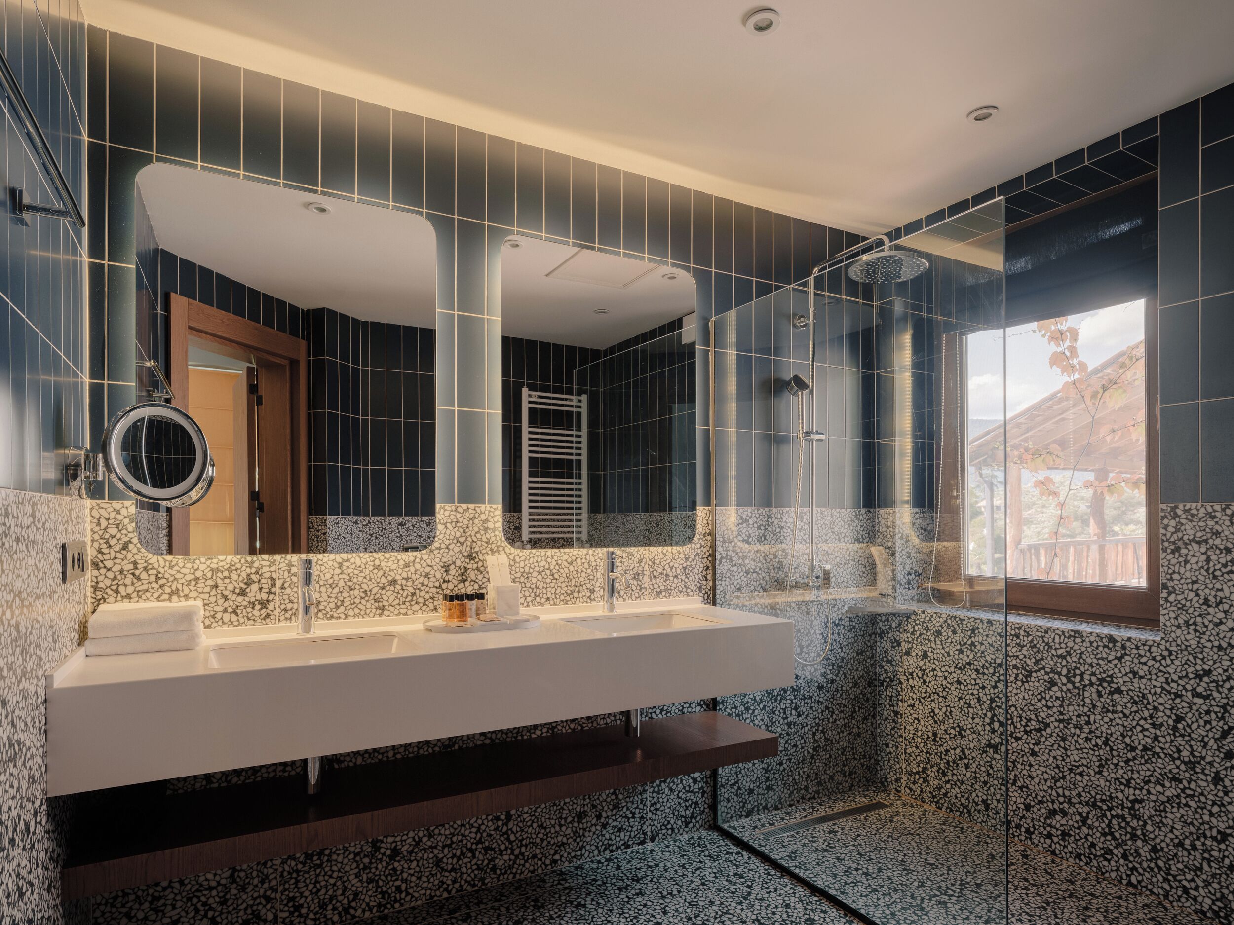 Un baño moderno con un espejo grande, una ducha y un lavabo.