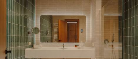 Ein Badezimmer mit großem Spiegel, Waschbecken, Toilette und Duschbereich.