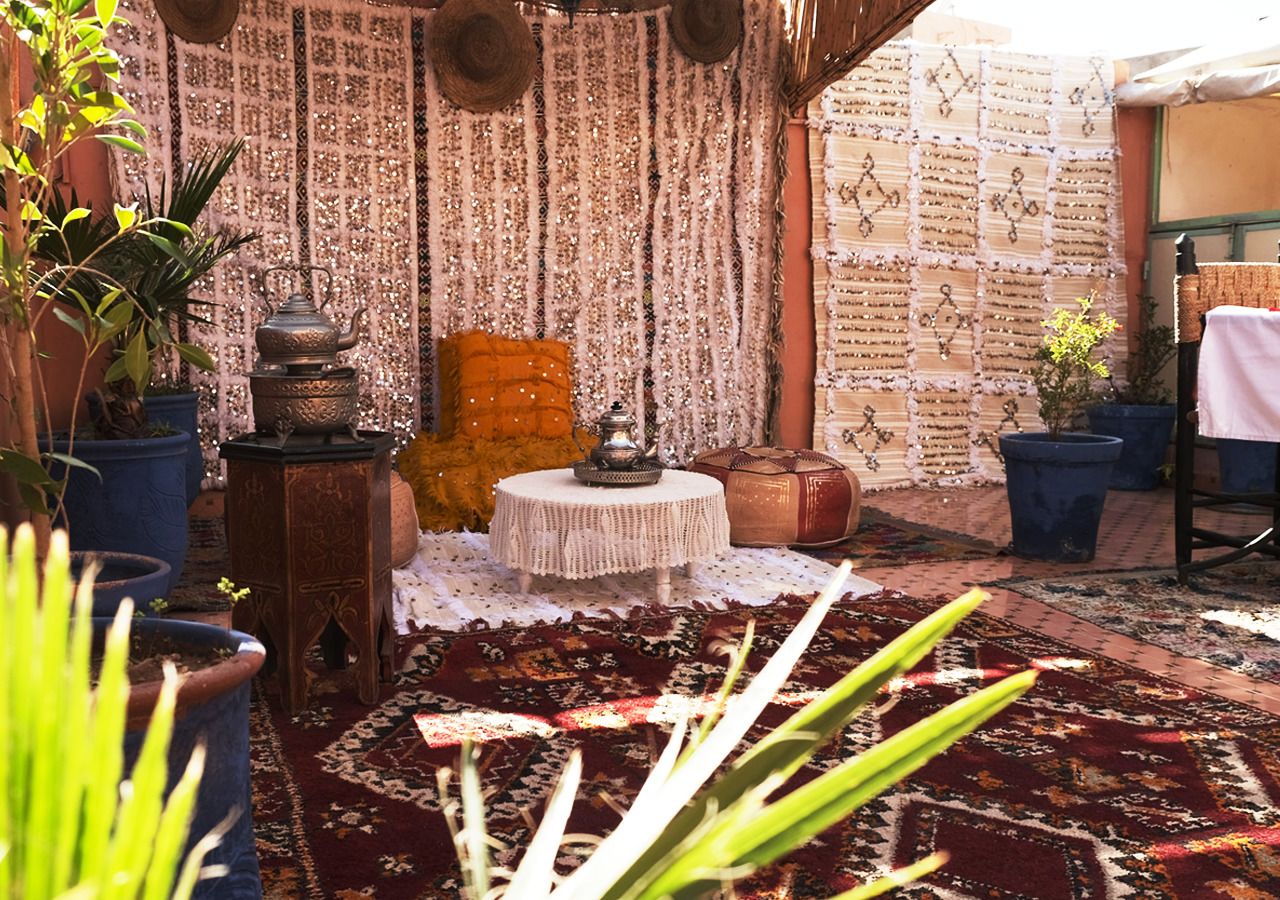A cozy outdoor seating area with a patterned rug, a small round table, and decorative items.