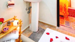 A bathroom with a sink, mirror, and a wooden rack with toiletries. - Riad Dar Benbrahim (Marrakech)