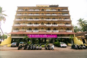 A multi-story hotel with a red-tiled roof, balconies, and a sign for 'RE:GEN:TA INN'. - Regenta Inn Palacio De Goa (Panaji)