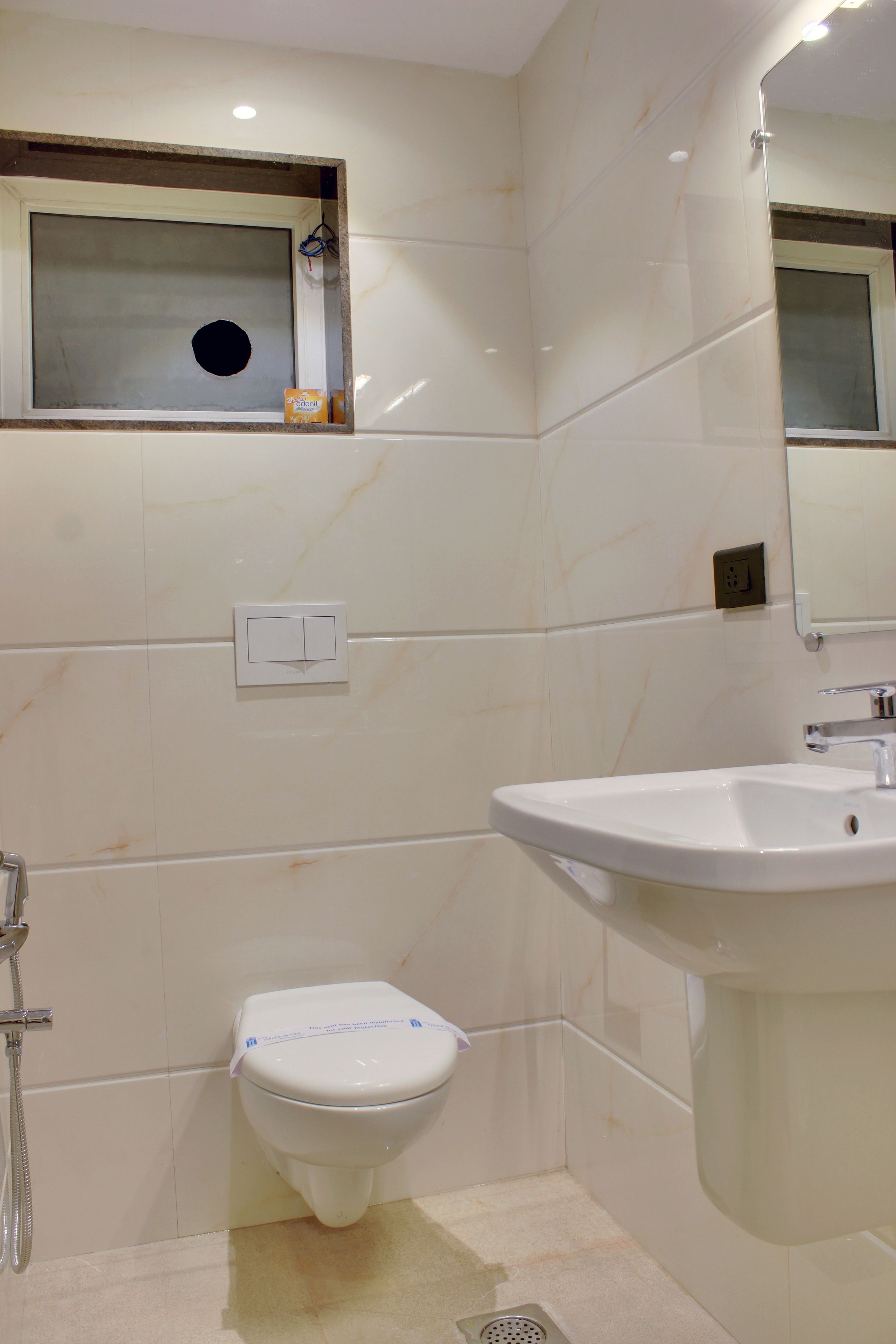 A bathroom with a toilet, sink, and mirror.