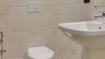 A bathroom with a toilet, sink, and mirror.