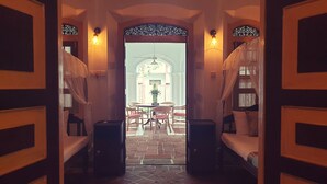A corridor leading to a dining area with a view of a building through a glass door. - Nooit Gedacht Heritage Hotel-Original Dutch Governor's House (Unawatuna)