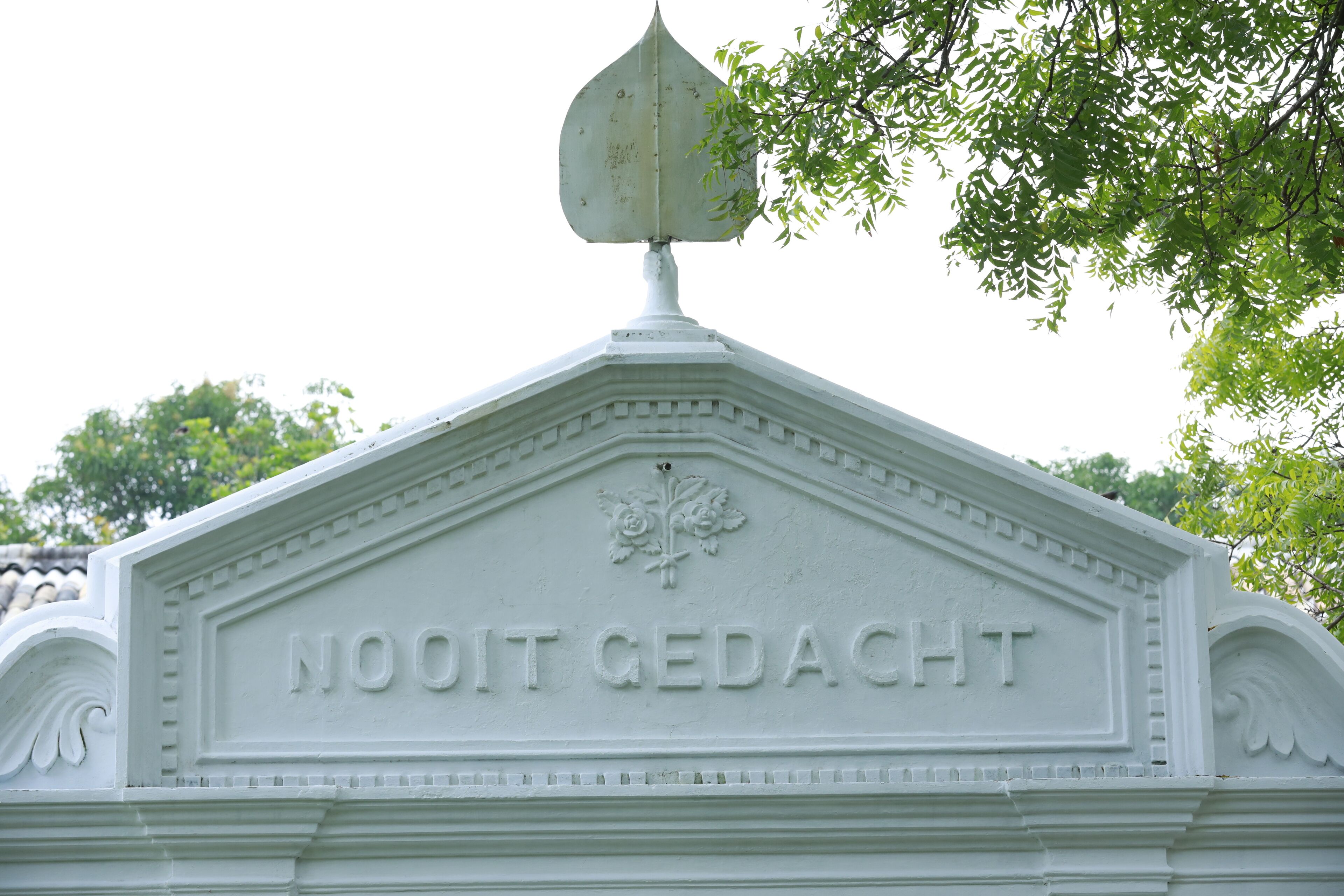 A white building with the inscription "NOOIT GEDACHT" on its facade.