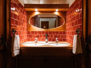 A bathroom with two sinks, a large mirror, and red-tiled walls. - Langley Hotel La Vieille Ferme (La Salle-les-Alpes)