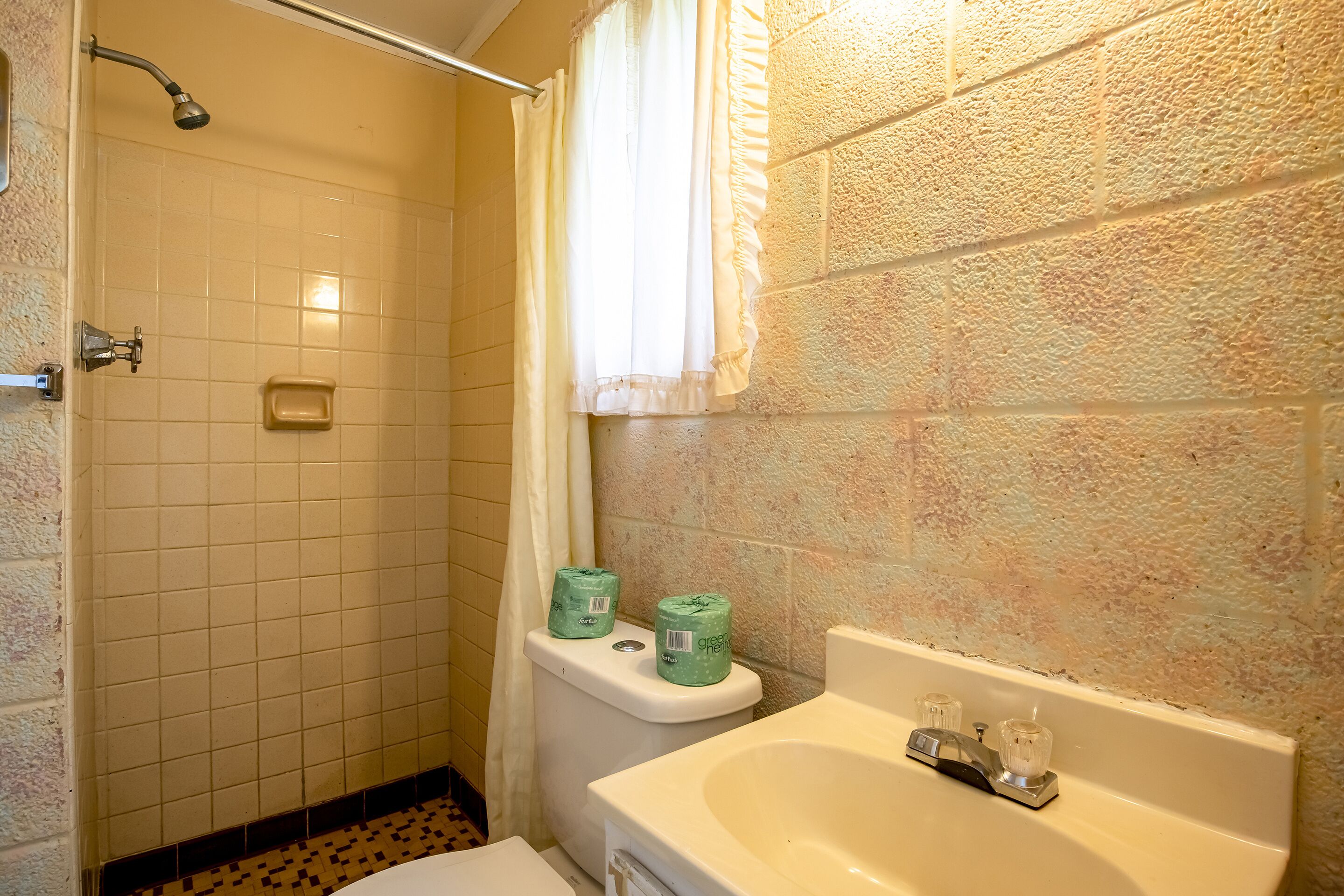 Un baño con ducha, inodoro y lavamanos.