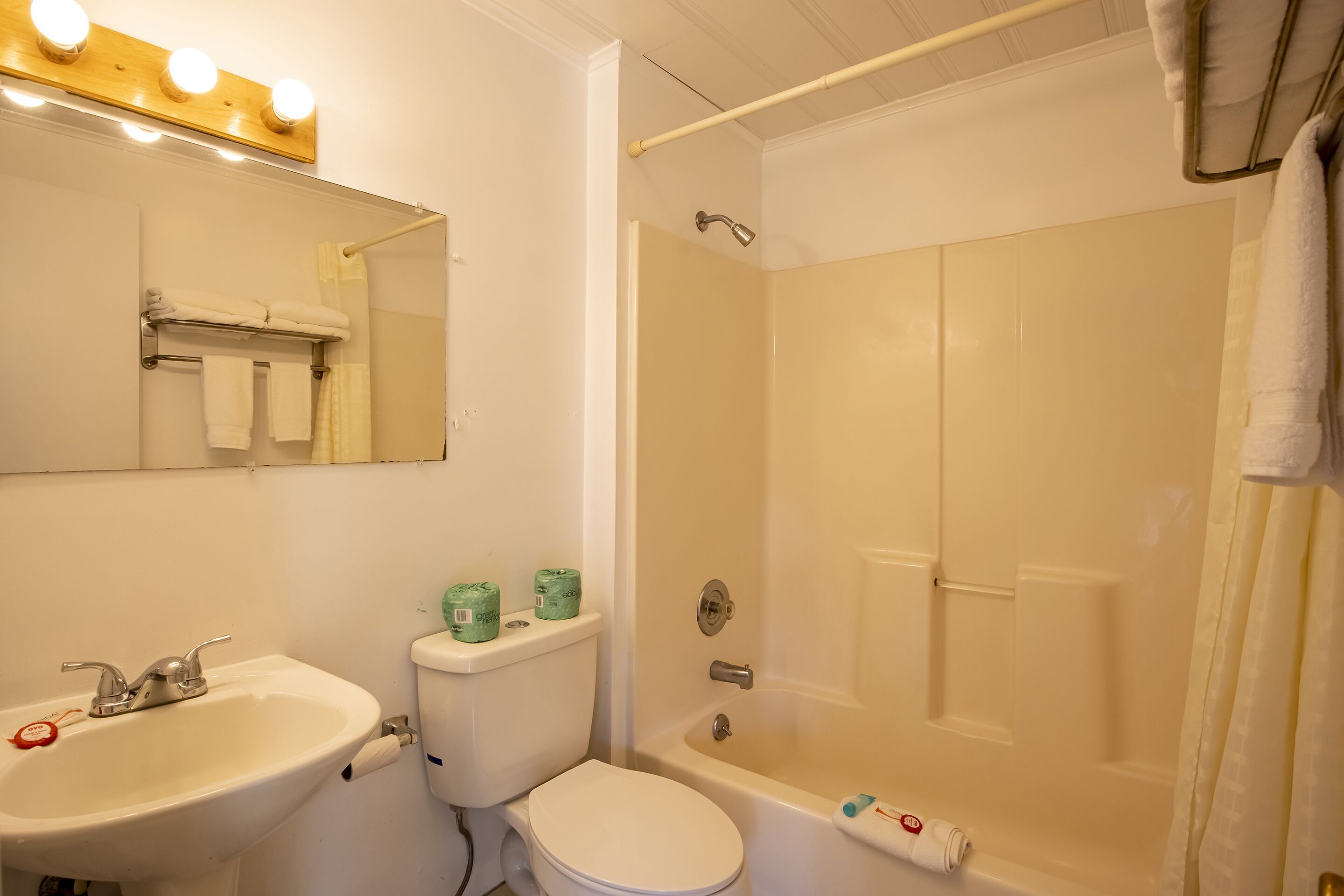 Een badkamer met wastafel, toilet en bad.