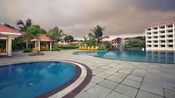 Una piscina al aire libre, sillones reclinables de piscina