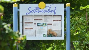 ein Schild für das Sonnenhof Hotel mit einer Speisekarte und Informationen.