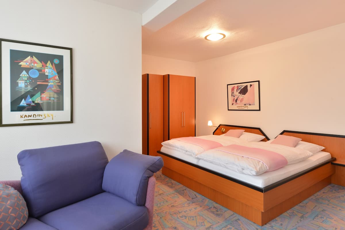 Un dormitorio con una cama, una silla y dos armarios.