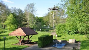 Ein Picknickunterstand, ein kleiner Pool und ein hohes Geb äude in einem Park.