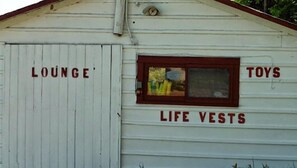 A white building with sections labeled 'Lounge', 'Toys', and 'Life Vests'. - Bruce Bay Cottages & Lighthouse (Bruce Mines)