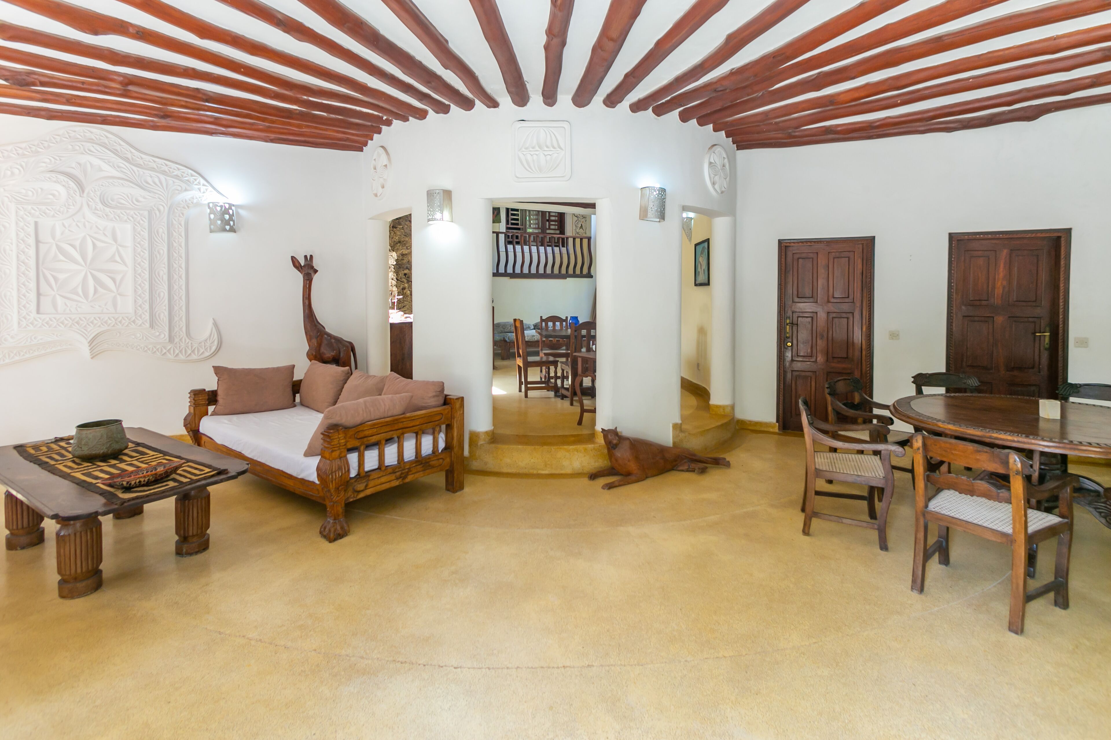 A spacious living area with a sofa, wooden coffee table, and a dining table with chairs.