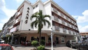A multi-story hotel with a white facade, balconies on each floor, and a palm tree in front. - Hotel Lotte (Ipoh)