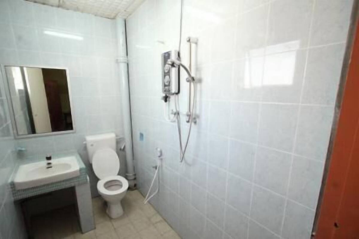 A bathroom with a toilet, sink, and shower.