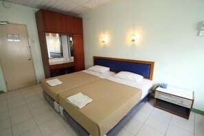 A hotel room with a large bed, a wooden wardrobe, two wall-mounted lights, and a small bedside table. - Hotel Lotte (Ipoh)