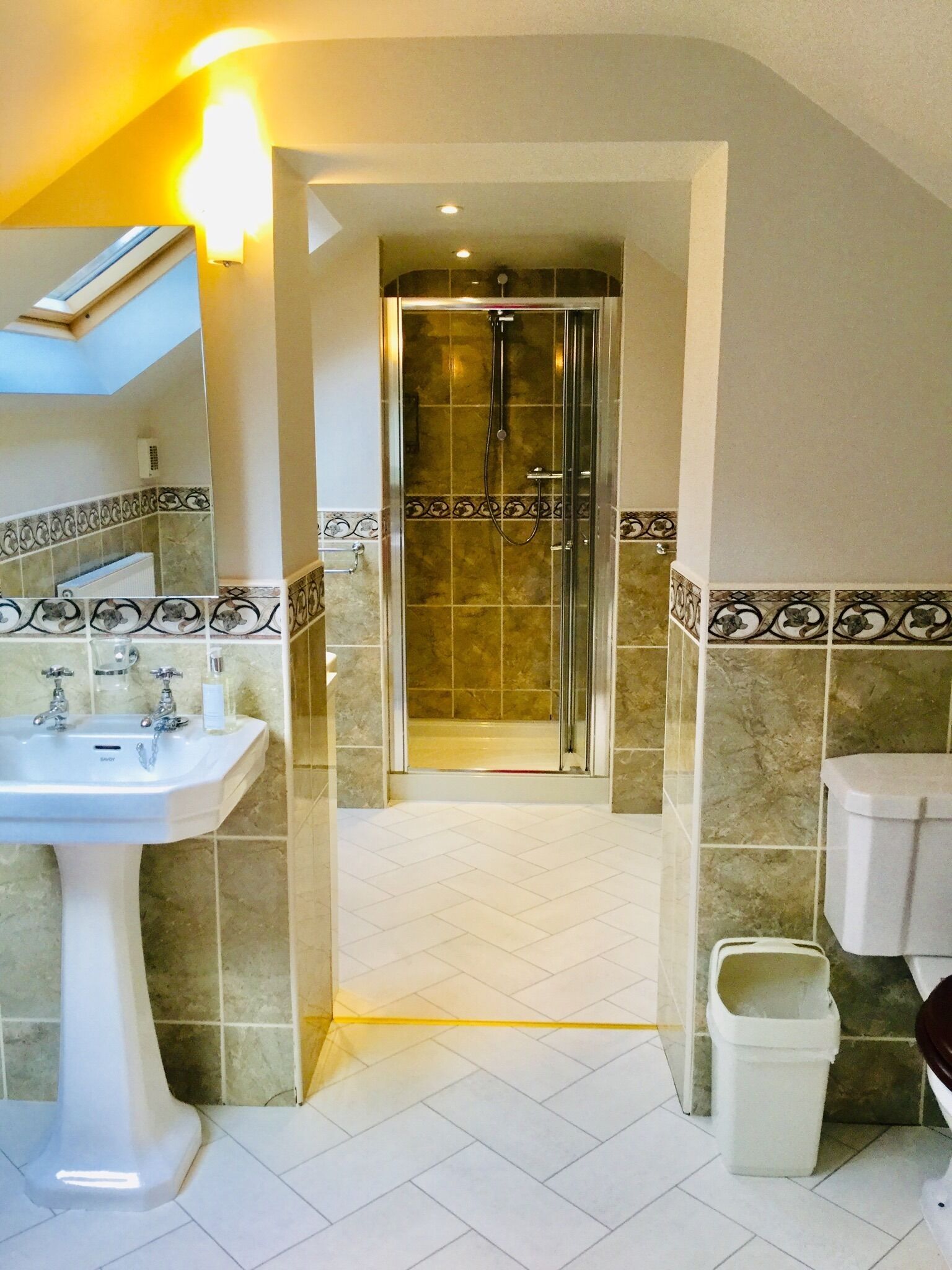 Een badkamer met douche, wastafel en toilet.