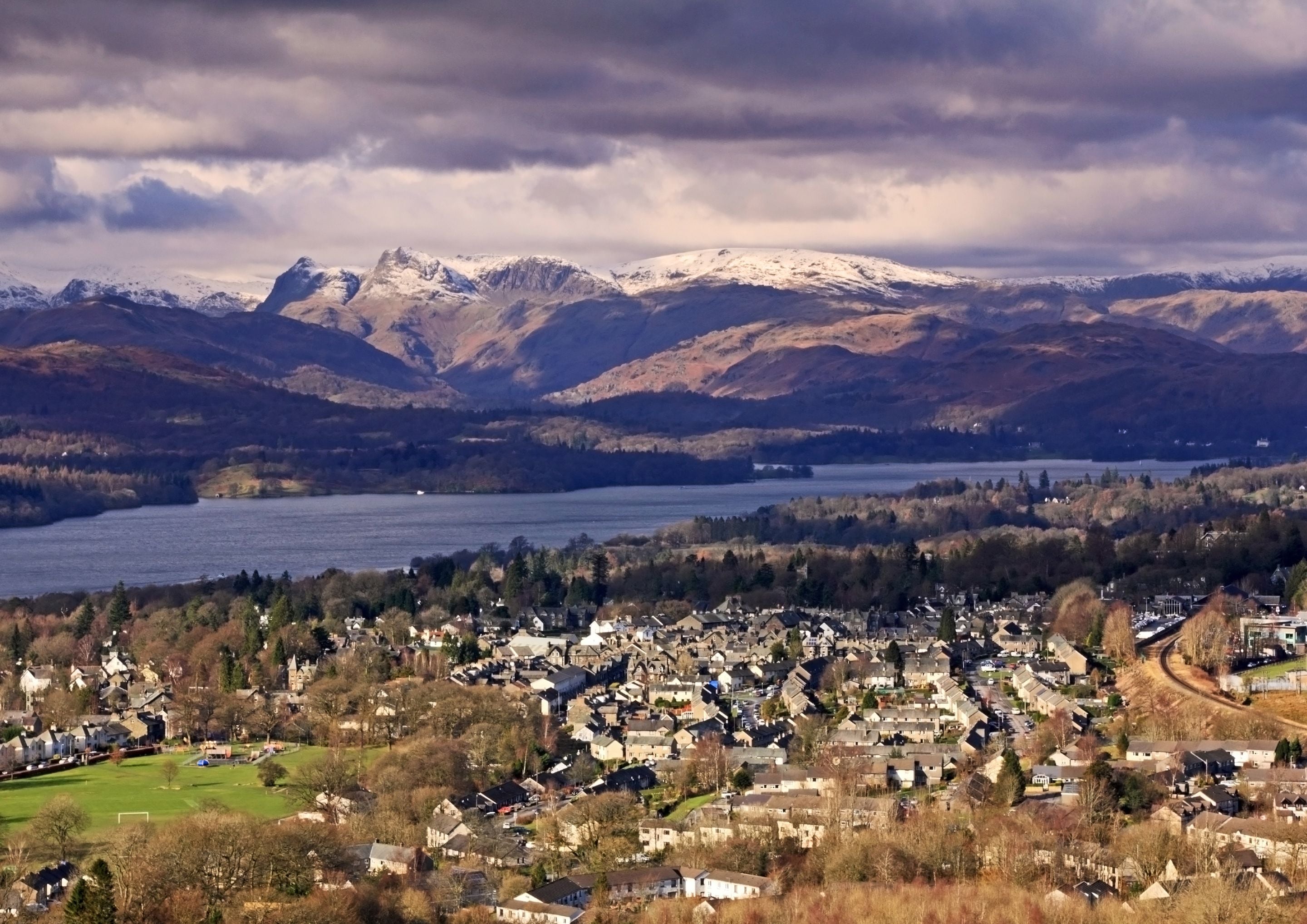 A town with a lake, mountains, and a mix of residential and commercial buildings.